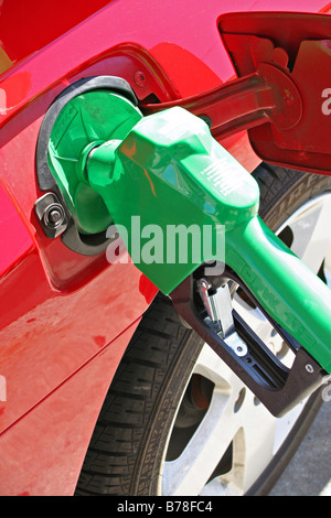 Pompe à gaz vert vif en voiture rouge Banque D'Images