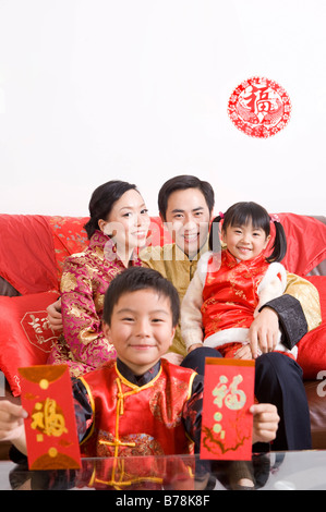 Une famille en vêtements traditionnels célébrant le Nouvel An chinois Banque D'Images