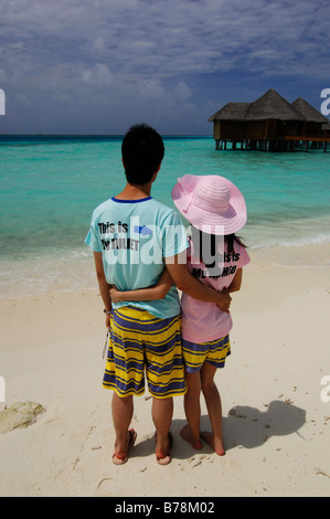 Les jeunes mariés japonais sur la plage le port de Romeo et Juliette T-shirts à Baros Resort, Maldives, océan Indien Banque D'Images