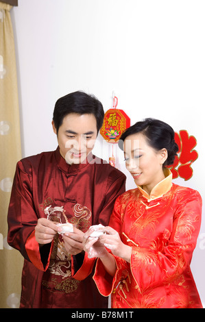 Jeune couple en vêtements traditionnels faisant ensemble quenelles Banque D'Images