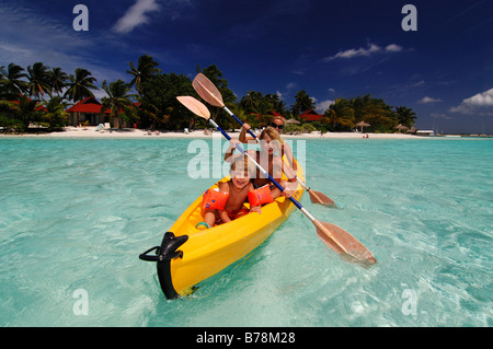 Femme avec enfants kayak au Kurumba Resort, les Maldives, l'océan Incian Banque D'Images