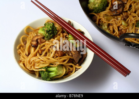 Chow mein Boeuf et un baguettes à partir de ci-dessus, avec la partie du wok en arrière-plan. Banque D'Images