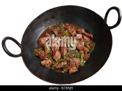 Un traditionnel wok en fonte contenant de la viande bovine et des poivrons dans le haricot noir,l'ail et gingembre,une cuisine cantonaise traditionnelle plat. Banque D'Images