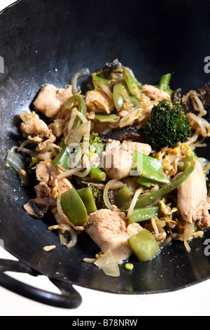 Un poulet et sauté de légumes dans un wok,une partie des ingrédients pour un chow mein au poulet Banque D'Images