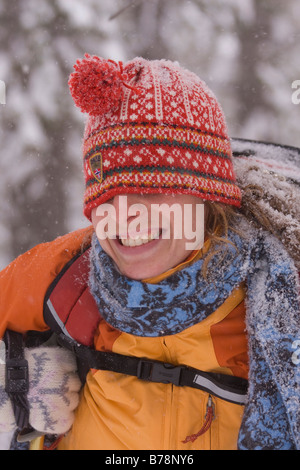 Une femme avec son chapeau tiré vers le bas sur son visage alors que la raquette lors d'une tempête de neige tempête près de Truckee en Californie Banque D'Images