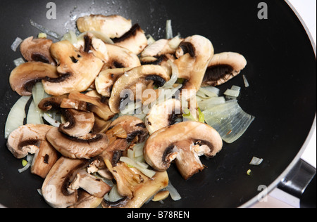 Un champignon et l'oignon faire revenir par cuisson dans un wok Banque D'Images