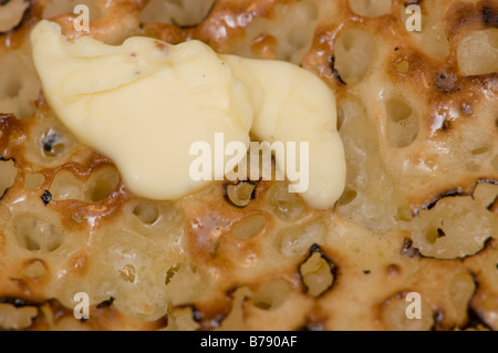 Gros plan sur la surface de Hot buttered toast crumpets avec du beurre fondant sur haut, UK Banque D'Images