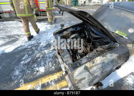 Moteur de voiture brûlée Pompiers Pompiers en mousse Banque D'Images