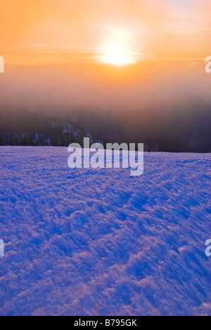 La neige soulevée par le vent et coucher de soleil depuis le sommet de Sentinel Dome Yosemite National Park California Banque D'Images