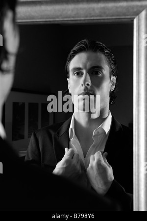 Young man looking at mirror Banque D'Images