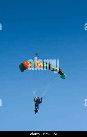 Le parachutisme CAMÉRA HOMME SOUS LE COUVERT CONTRE UN CIEL BLEU Banque D'Images