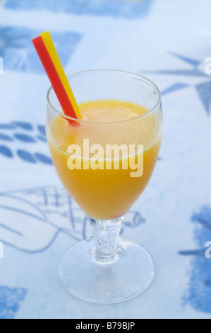 Verre à jus d'orange et 2 pailles sur fond bleu Banque D'Images
