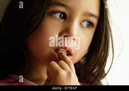 Petite fille de cinq ans chews nails Banque D'Images