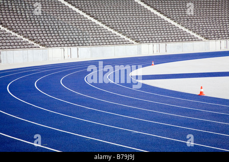 Une piste de course en stade vide piste bleue contre l'arrière-plan de rangées de sièges vides Banque D'Images