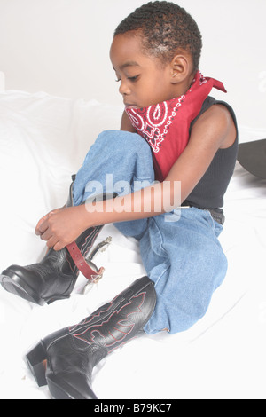 African American boy playing cowboy, cerclage sur ses éperons Banque D'Images