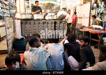 Un homme sert de la nourriture d'énormes casseroles dans une des ruelles fonctionnant en bas de Chandi Chowk, Delhi, Inde. Banque D'Images