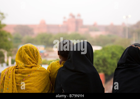 Les femmes musulmanes s'asseoir sur les marches de la Jama Masjid à Delhi, en Inde. Elles donnent sur le Fort Rouge. Banque D'Images