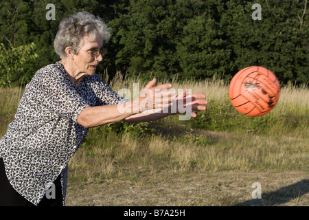 Vieille Femme par le jeu avec ballon Banque D'Images