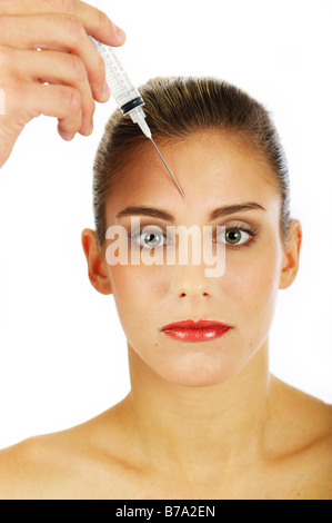 Young woman getting an injection contre les rides du front Banque D'Images