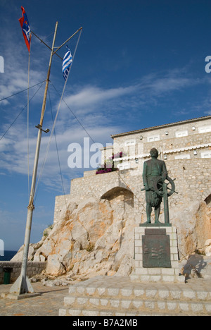 Drapeau grec et Hydra voler près de la figure de bronze de l'amiral de la flotte d'Hydraiot Miaoulis à partir de la révolution de 1821, la Ville d''Hydra, Grèce Banque D'Images