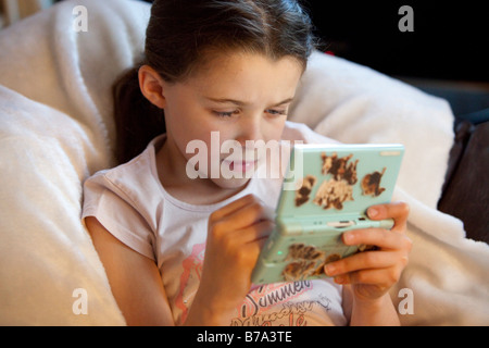 Jeune fille jouant avec jeu Nintendo DS Lite Banque D'Images