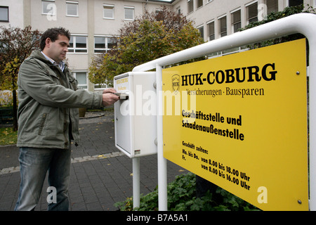 Client de HUK Coburg mettre une lettre dans la boîte aux lettres de l'Agence d'indemnisation Coburg HUK HUK, guanaco, Cobourg, Bavière, Allemagne Banque D'Images