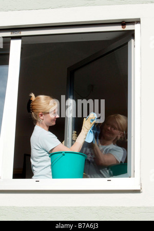 Young woman cleaning windows Banque D'Images