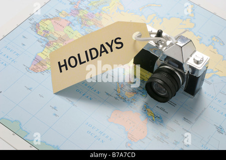 Appareil photo sur carte du monde avec 'vacances' tag