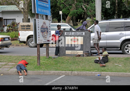 Les jeunes vendeurs de rue de bois sculpté des souvenirs aux touristes, en faisant une pause, Santa Lucia, Afrique du Sud, l'Afrique Banque D'Images