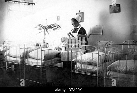 Photo historique, infirmière et bébé dans l'hôpital, ca. 1910 Banque D'Images