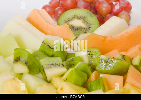 Tranches de fruits exotiques, le sucre melon, melon miel, ananas, kiwis et raisins Banque D'Images