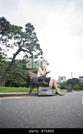 Young woman eating lunch dans un parc, Tokyo, Japon, Asie Banque D'Images