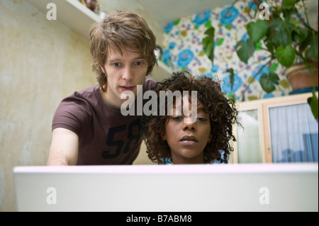 Jeune couple travaillant sur un ordinateur portable, Allemagne Banque D'Images