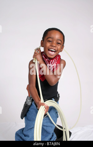 African American boy playing cowboy, en utilisant son laso Banque D'Images