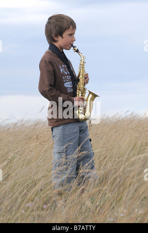 Garçon à jouer du saxophone dans le champ Banque D'Images