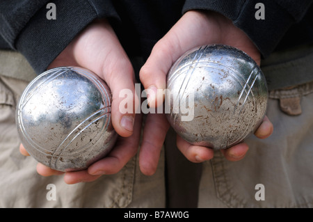 Boy's Hands Holding Boules de pétanque Banque D'Images