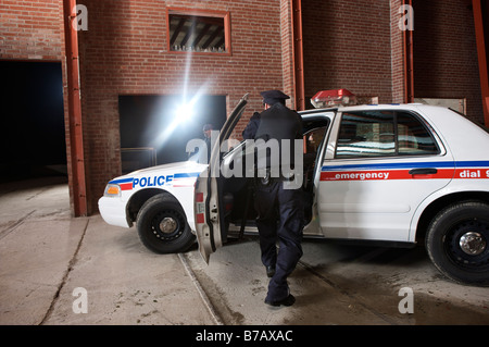 Agent de police derrière votre porte à coups tirés Banque D'Images