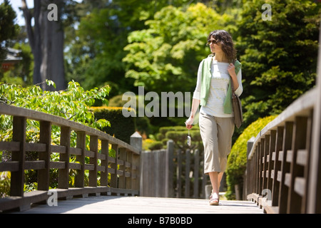 Femme Marchant sur pont de la Japanese Tea Garden dans le Golden Gate Park, San Francisco, California, USA Banque D'Images