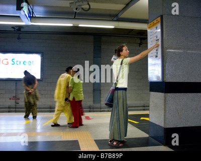 Une femme occidentale vérifie les informations touristiques sur une plate-forme à Chandni Chowk. Delhi Metro Rail system. L'Inde.(45) Banque D'Images