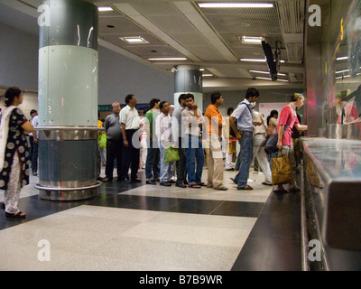 Une file d'attente des passagers l'achat des billets de voyage / jetons sur la Delhi Metro Rail system. Banque D'Images