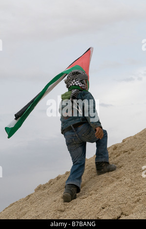 Enfant bédouin tient le drapeau palestinien dans le village du Néguev d'Ar'arat un-Naqab au cours d'une protestation contre la poursuite de l'opération militaire à Gaza Banque D'Images