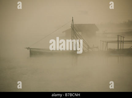 Tôt le matin, le brouillard et la lumière du soleil sur le lac Khao Laem Sangklaburi en Thaïlande Banque D'Images