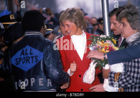 Diana, princesse de Galles dans une veste rouge entouré de sympathisants de l'hôpital de Harlem visites unité pédiatrique contre le SIDA à Harlem. New York City, USA. 1989 Banque D'Images