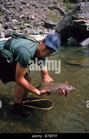 Un homme tient une grosse truite arc-en-ciel lors de la pêche à la mouche à l'gunnison River dans le black canyon national park Banque D'Images