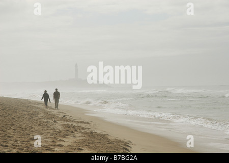 23 septembre 2008 Couple walking on beach, près du Cap sur le phare de Trafalgar Andalousie Espagne Banque D'Images
