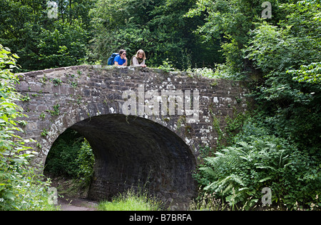 Deux femmes les marcheurs se penche au pont-canal et le canal de Brecon Monmouthshire au Pays de Galles UK Banque D'Images