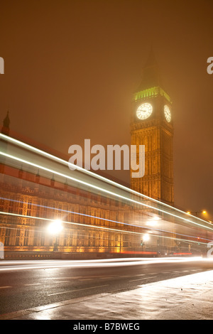 Big Ben et des chambres du Parlement sur une nuit d'hiver brumeux, avec feu de signalisation des sentiers. Westminster, London, England, UK Banque D'Images