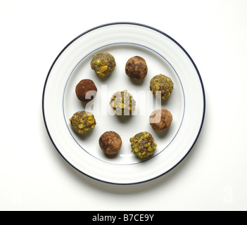 Un cercle de truffes au chocolat sur une assiette blanche ronde. Également connu sous le nom de bonbons ou profiteroles Banque D'Images