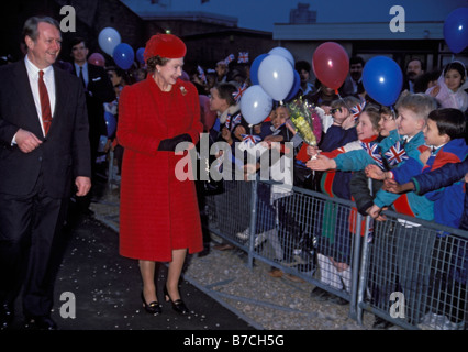 A smiling Son Altesse Royale la Reine Elizabeth II d'être accueillis par les enfants au Queen Mary College. Londres, Angleterre, 1989 Banque D'Images