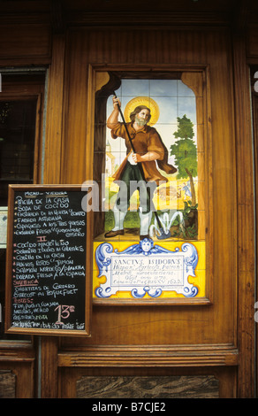 Carreaux de céramique peints montrant la scène avec Isidore the Louvrier / San Isidro Labrador et le menu déjeuner à l'extérieur du bar à tapas, Madrid, Espagne Banque D'Images